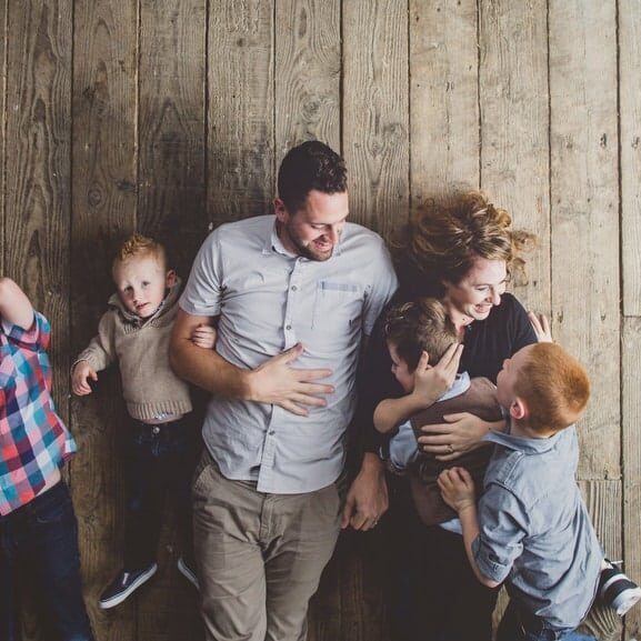 Family having fun tickling on old wood floor